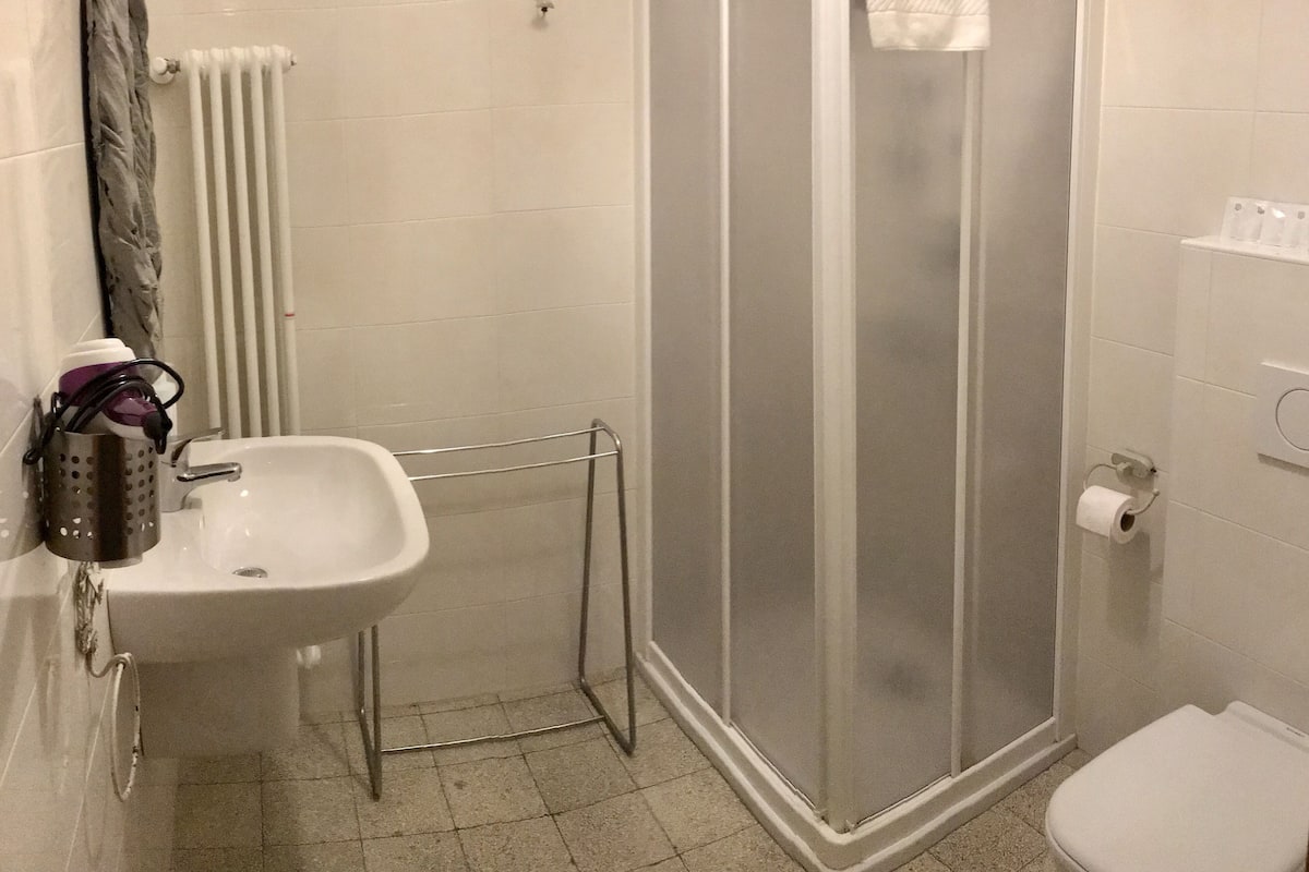 Un baño con ducha, lavabo e inodoro.