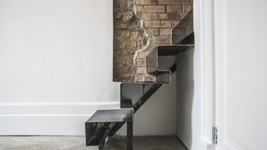 Una escalera moderna con pared de ladrillo y barandillas metálicas.