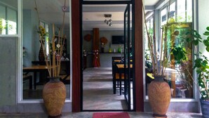 An interior view of a room with a dining area, a large window, and two large vases.
