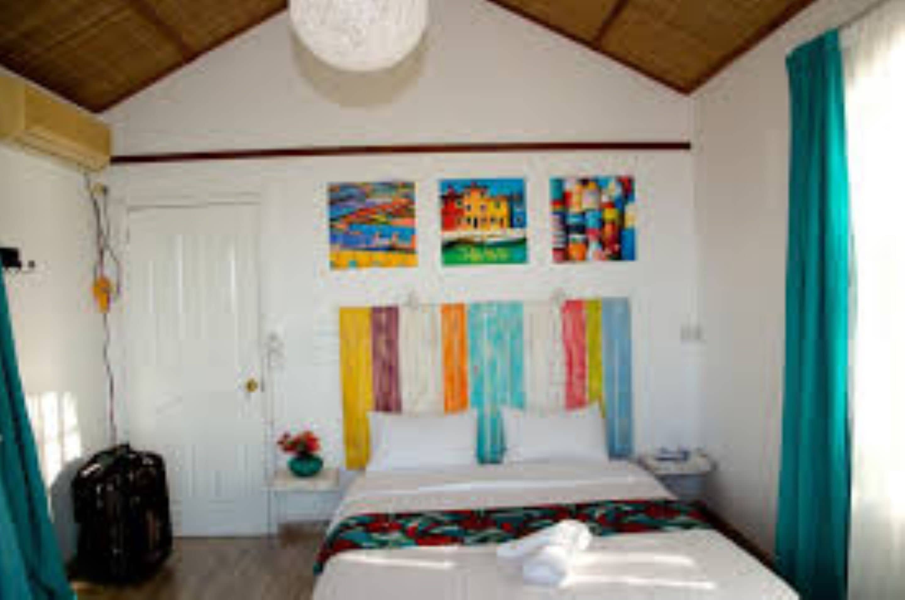Un dormitorio con cama, cortinas coloridas y ventilador de techo.