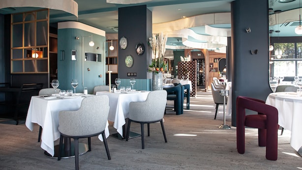 A restaurant with round tables, grey chairs, and a mix of blue and dark walls. - LOGIS HOTEL RELAIS SAINT JACQUES (Coings)