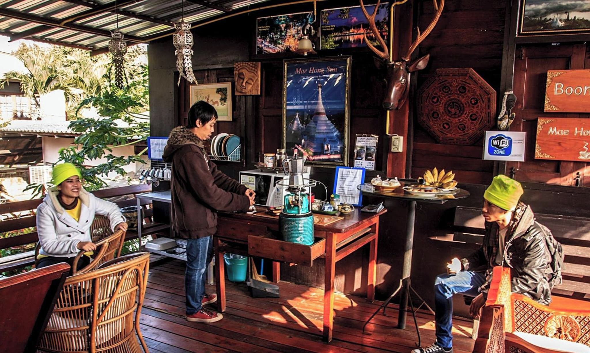Un espacio al aire libre con mobiliario de madera, una cafetera y un tablero de menú.