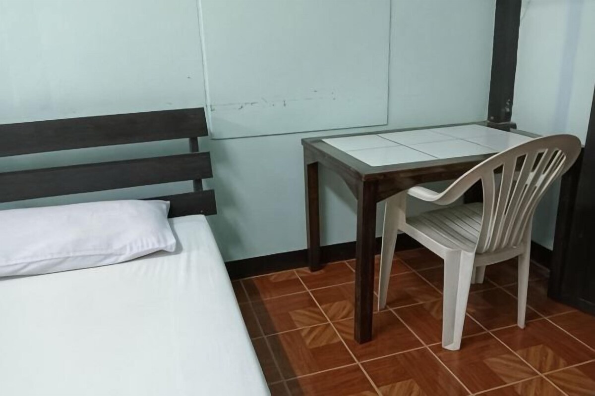 A room with a bed, a desk, and a chair.