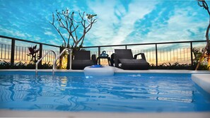 Un espace piscine avec des chaises longues et une vue sur le ciel.