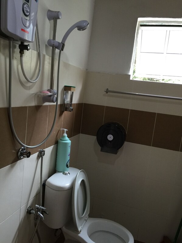 Un baño con inodoro, ducha y secamanos.