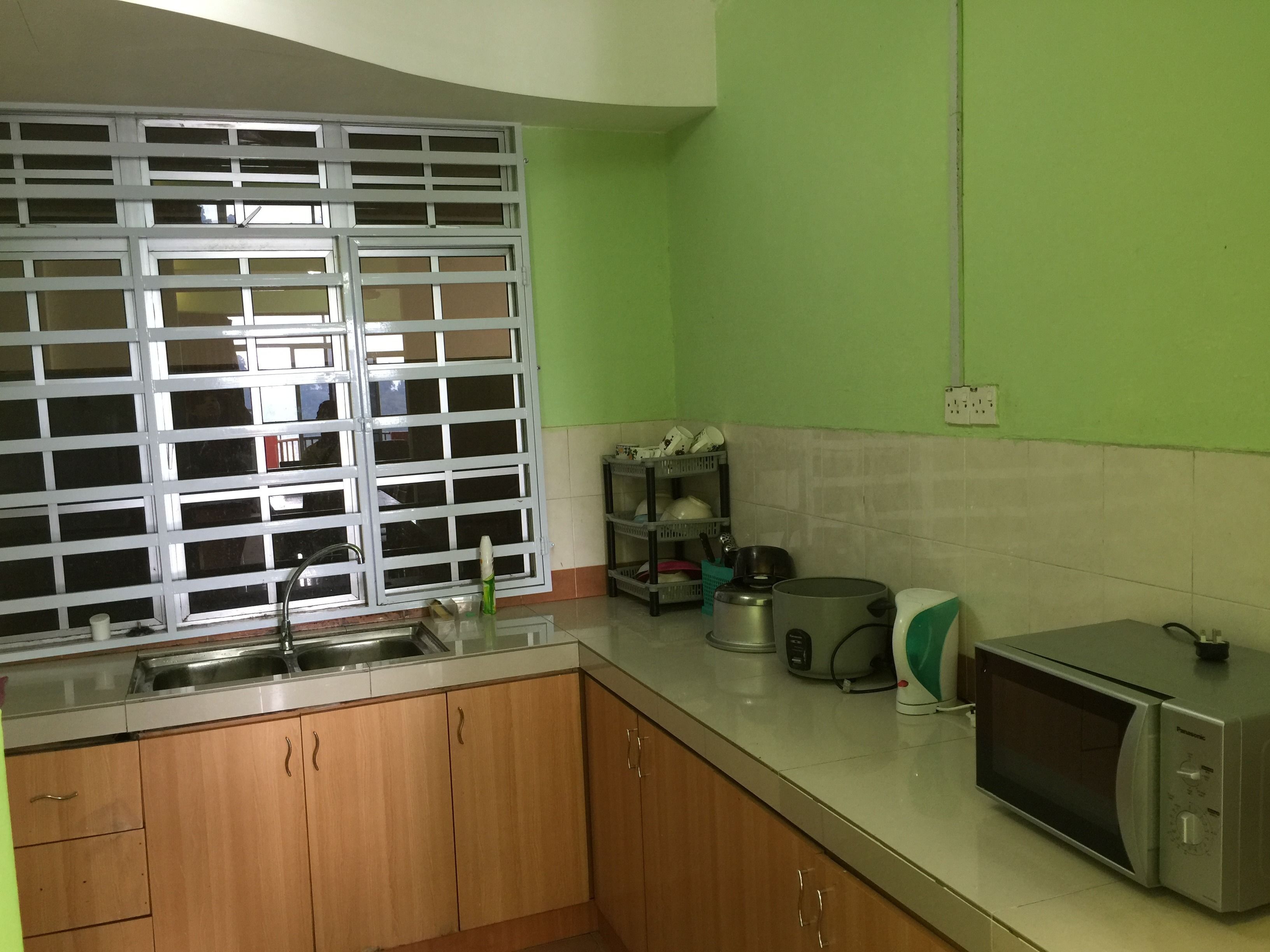 A kitchen with wooden cabinets, a sink, a microwave, and a stove.