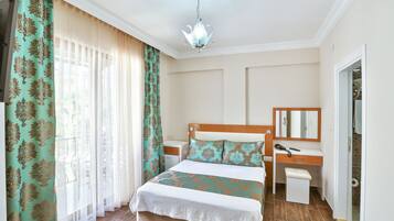 Un dormitorio ordenado con cama, mesita de noche y espejo.