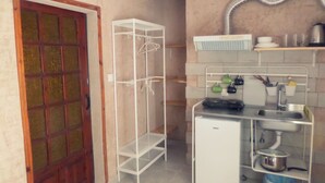 Una cocina compacta con refrigerador, lavamanos y una pequeña encimera.