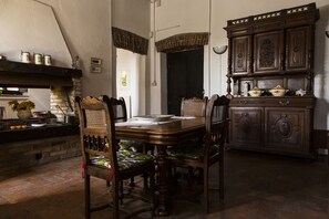 A traditional dining room with a wooden table, four chairs, and a dark wooden cabinet with ornate carvings. - La Locanda di Sant'Anna (Truccazzano)