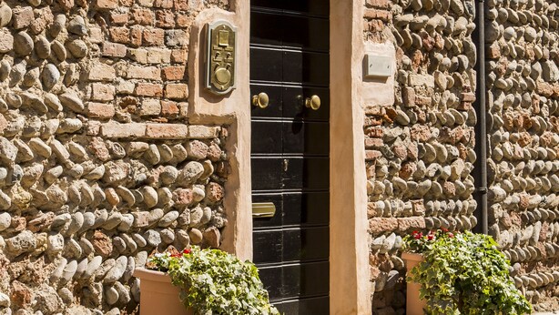 A stone building with a sign reading "LA LOCANDA di Sant'Anna" and a black door. - La Locanda di Sant'Anna (Truccazzano)
