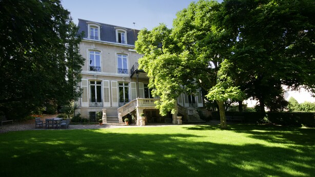 A two-story house with a balcony, a front porch, and a well-maintained lawn. - L'Hôtel Particulier (Nancy)