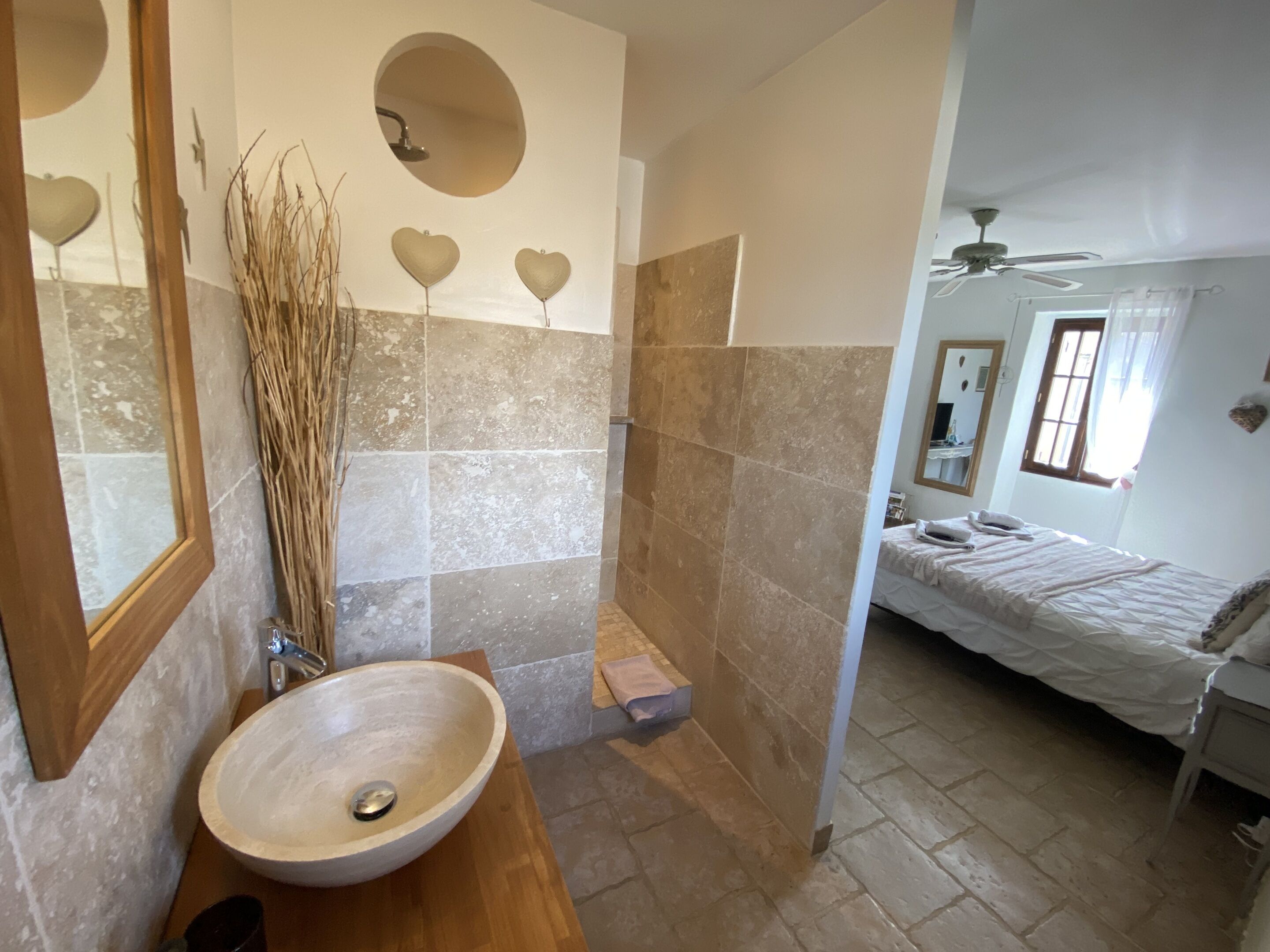 A bathroom with a wooden vanity, a large basin sink, and a shower area.