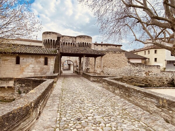Un sendero de piedra que conduce a un edificio histórico con arcos y tejado de azulejos.