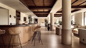 Un intérieur spacieux comprenant un bar, des espaces pour s’asseoir et de grandes fenêtres.