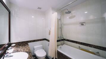 A bathroom with a toilet, sink, and bathtub.