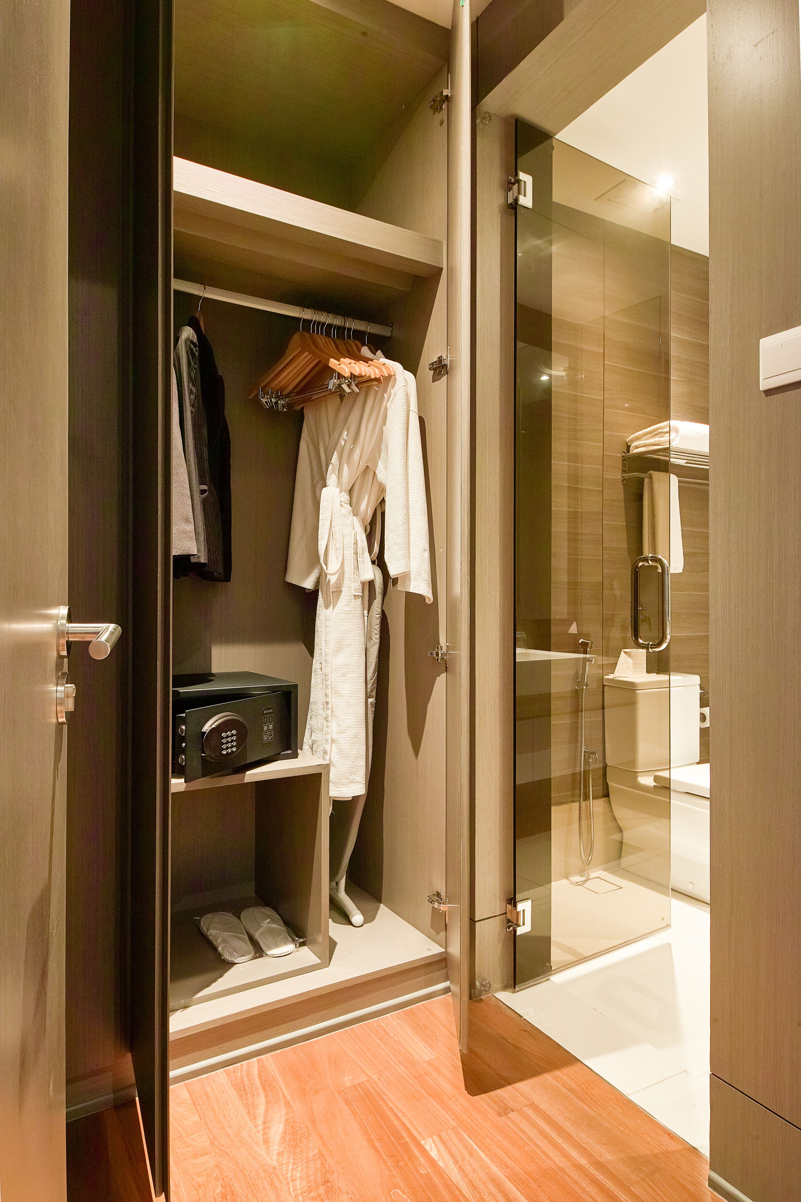 A walk-in closet with a robe hanging, a shoe shelf, and a microwave.