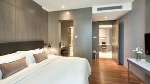 A modern hotel room with a large bed, a desk, and a shower area. - V E Hotel & Residence (Kuala Lumpur)