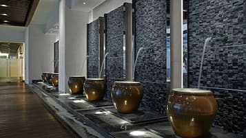 Experience the sleek, contemporary design of our lobby, featuring large vases and a textured mosaic wall.