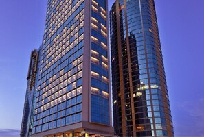 Two high-rise buildings with reflective glass facades and illuminated windows, suggesting a modern urban setting. - V E Hotel & Residence (Kuala Lumpur)