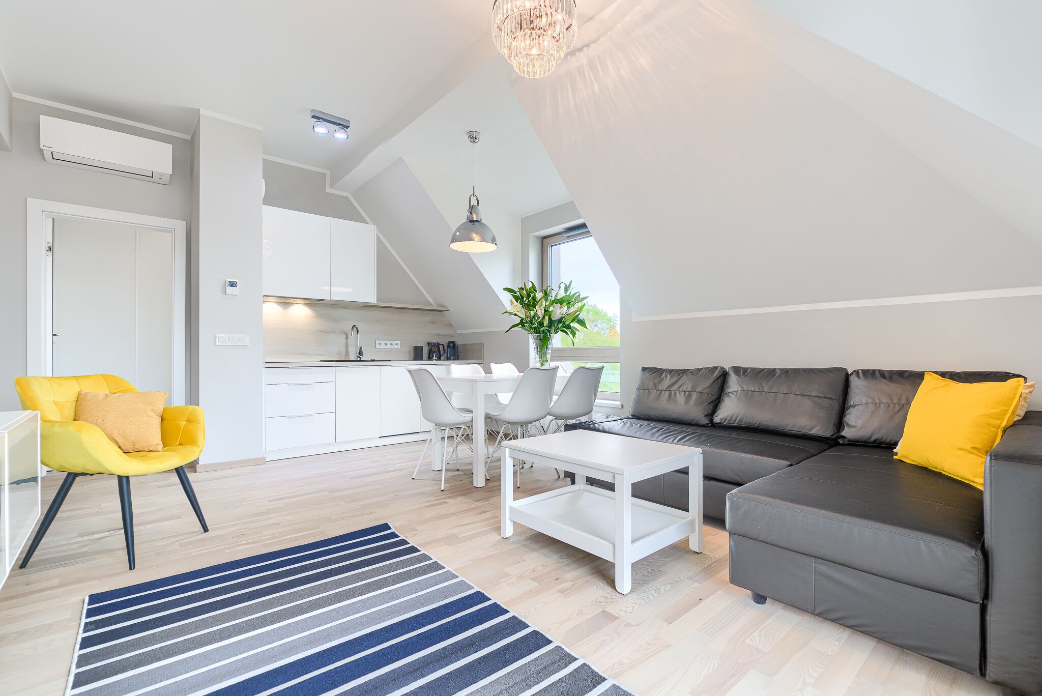 Ein modernes Wohnzimmer mit einer Couch, einem Couchtisch und einem Essbereich mit Stühlen.