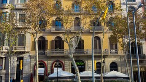 A multi-story building with a yellow facade, arched windows, and balconies. - Hostalin Barcelona Pg de Gràcia (Barcelona)