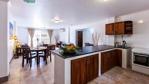 A modern kitchen with wooden cabinets, a black countertop, and a built-in oven. - Praslin Holiday Home (Praslin Island)
