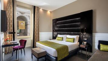 Een moderne hotelkamer met een groot bed, een bureau, een stoel en een kleine tafel.