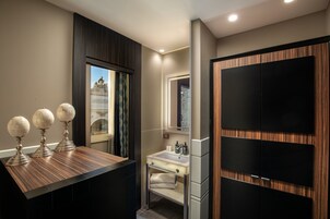 A modern bathroom with a vanity, a mirror, and a large wardrobe.