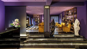 A modern lobby with a staircase, seating area, and a reception desk. - The Tribune, part of JdV by Hyatt (Rome)
