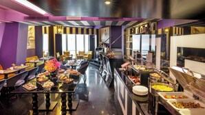A buffet setup with various food items and a seating area with chairs. - The Tribune, part of JdV by Hyatt (Rome)