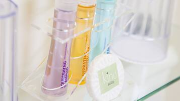 Un estante de baño con tres botellas de productos para el cabello y una pastilla de jabón.