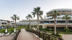 Un resort con piscina, palmeras y un paseo cubierto.