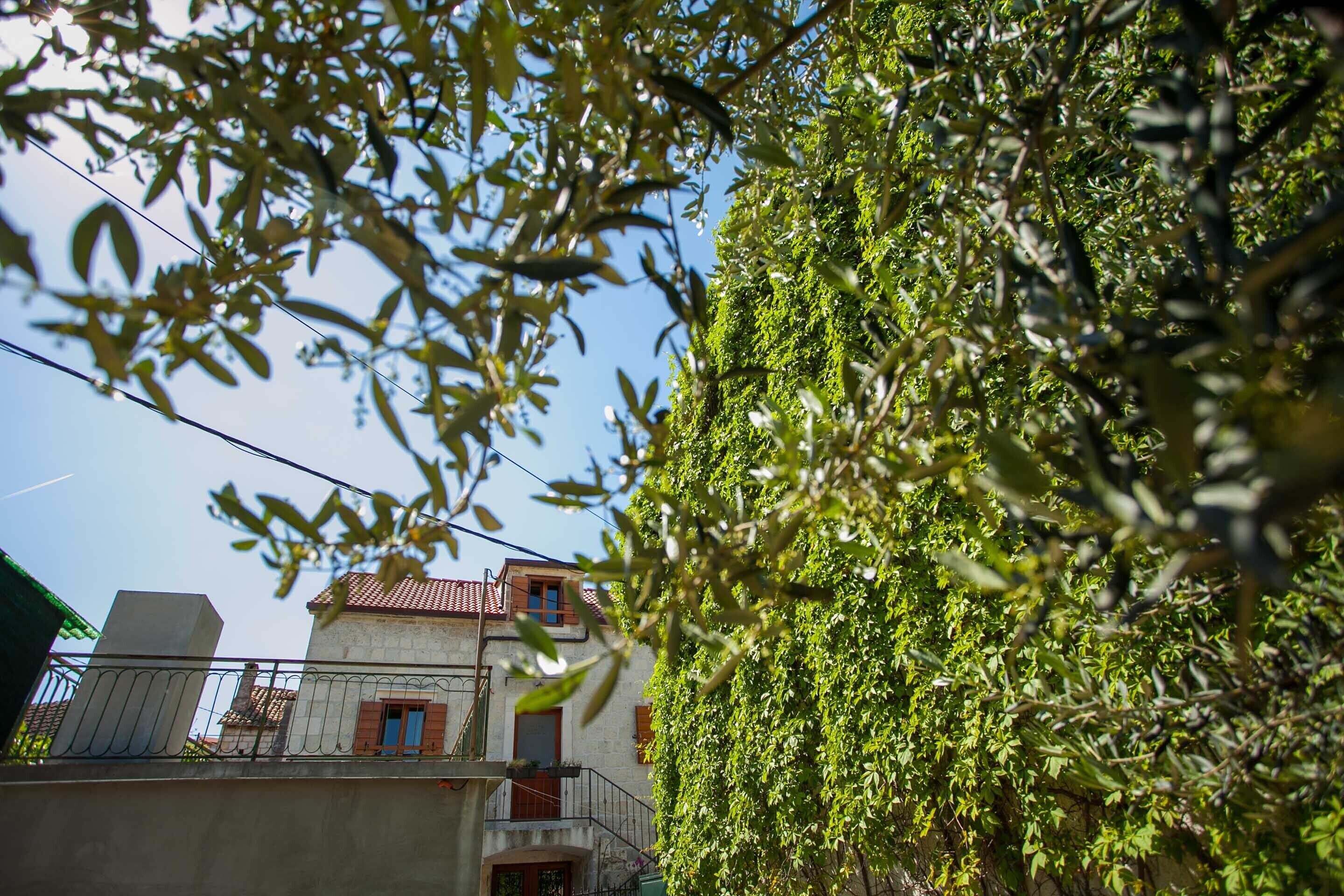 Un bâtiment avec un toit recouvert de tuiles rouges, un balcon et un mur blanc.