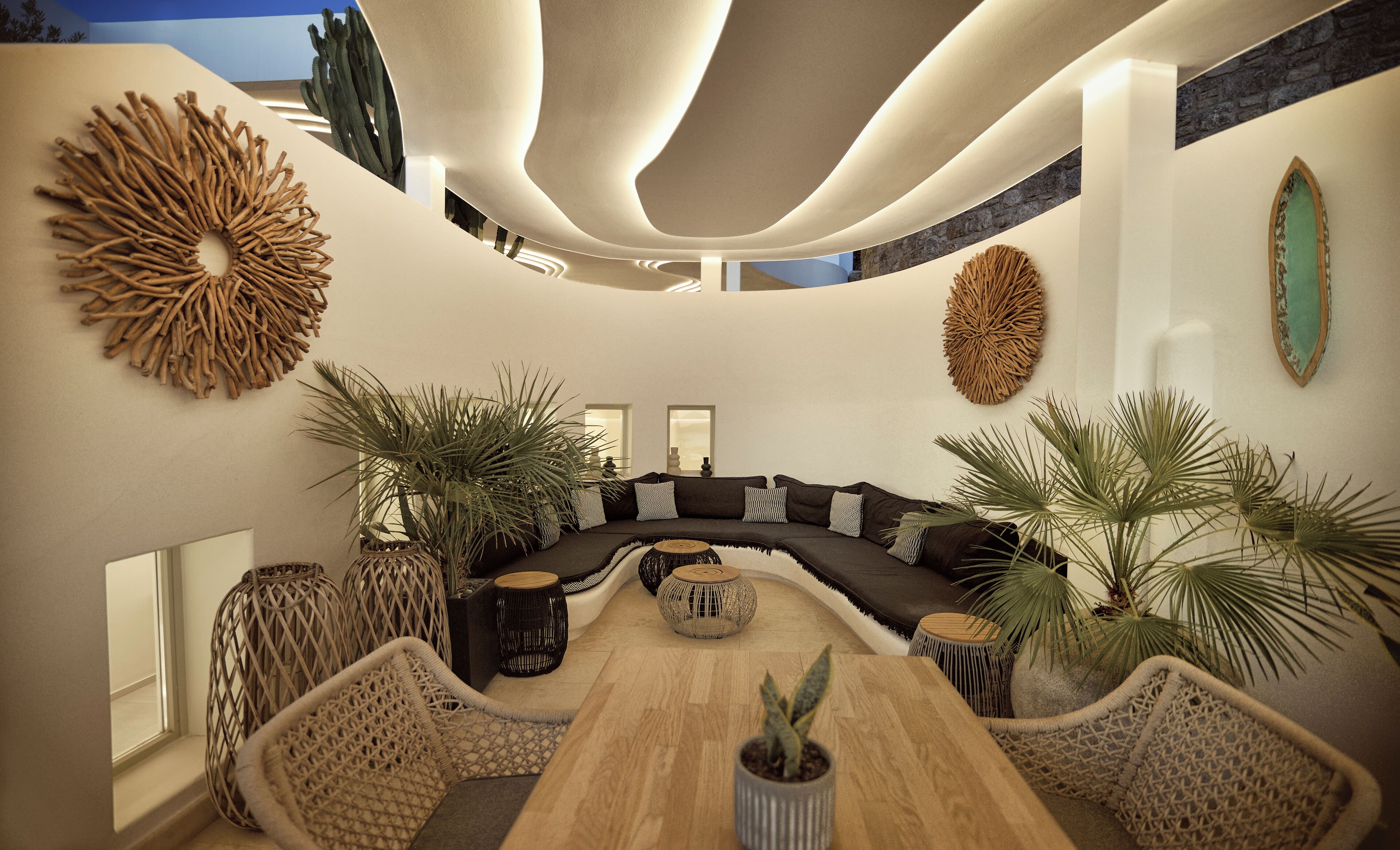 A modern living room with a curved sofa, a wooden coffee table, and various potted plants.