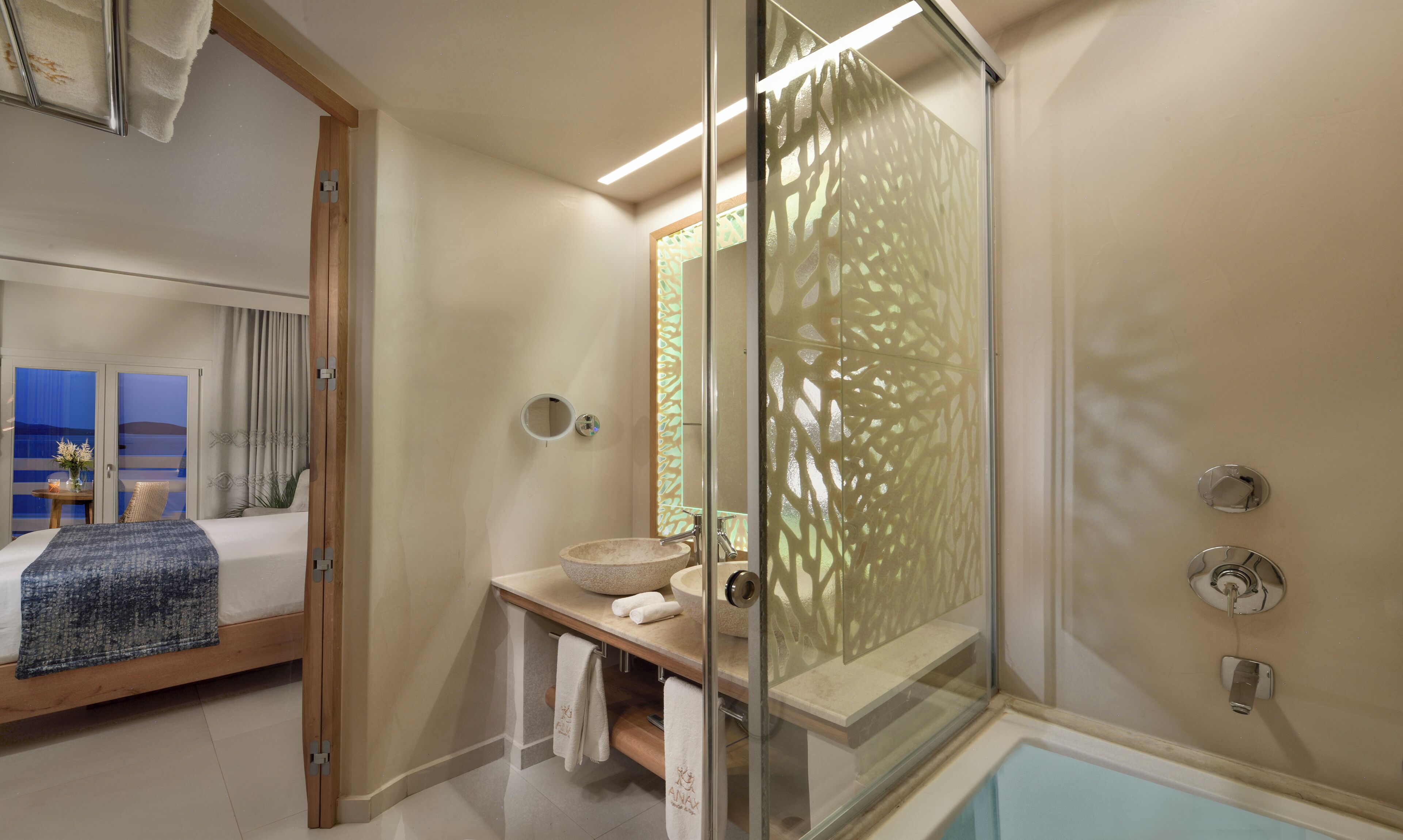 A modern bathroom with a glass-enclosed shower, a large round sink, and a bathtub.