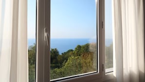 A window with a view of the sea and greenery. - Hotel Gudamendi (San Sebastián)