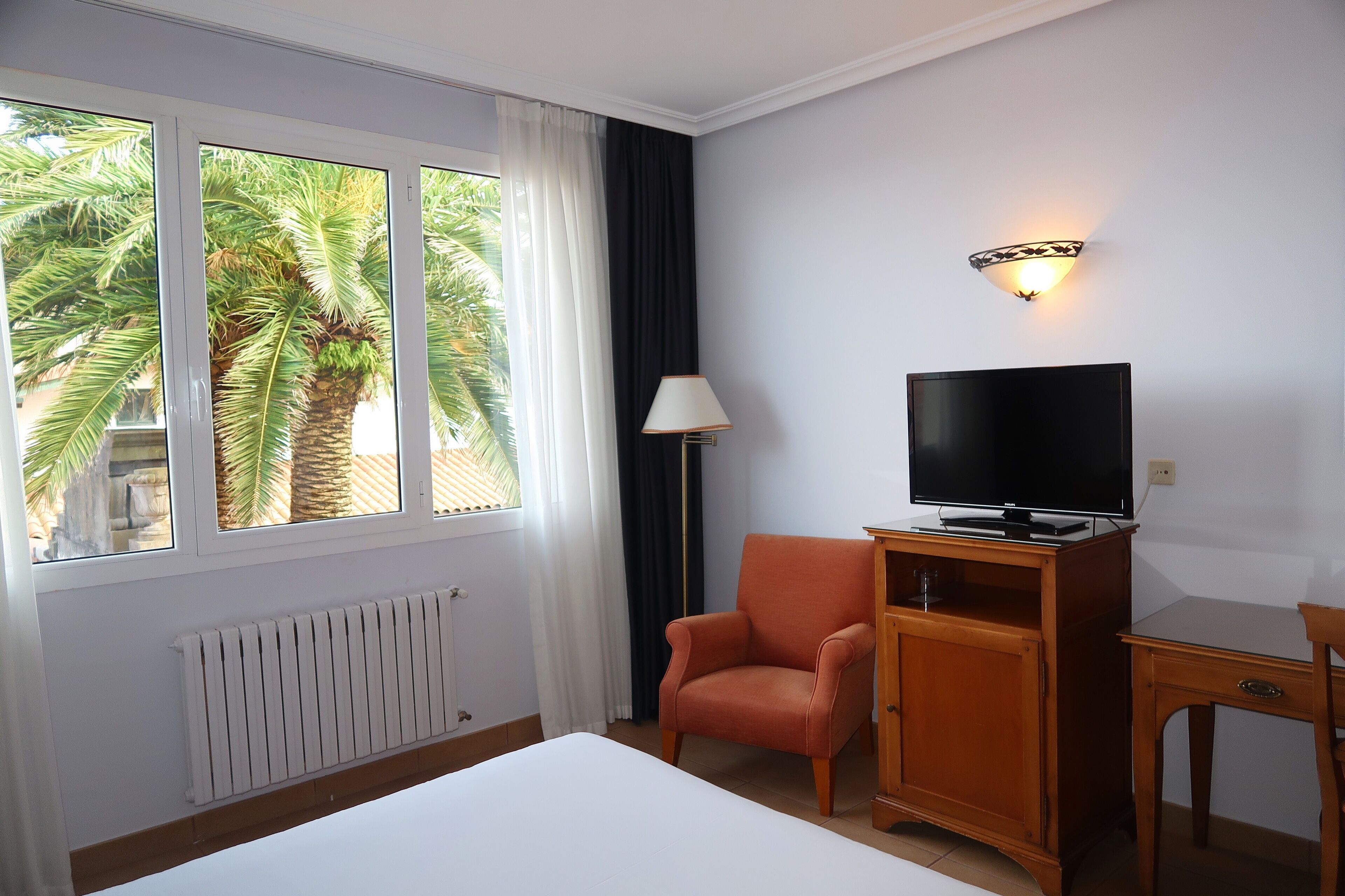 twin room, garden view | in-room safe, desk, blackout curtains, iron/ironing board