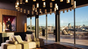A modern interior with a large window, a sofa, and a patterned rug. - Memmo Príncipe Real - Design Hotels (Lisbon)