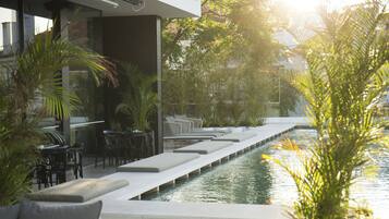 Relax by the pool surrounded by lush greenery and comfortable lounge seating.