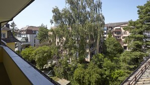 A residential area with multiple apartment buildings, trees, and a balcony railing. - City Stay Apartments Forchstraße (Zürich)