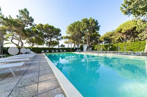 Una piscina al aire libre de temporada, sillones reclinables de piscina