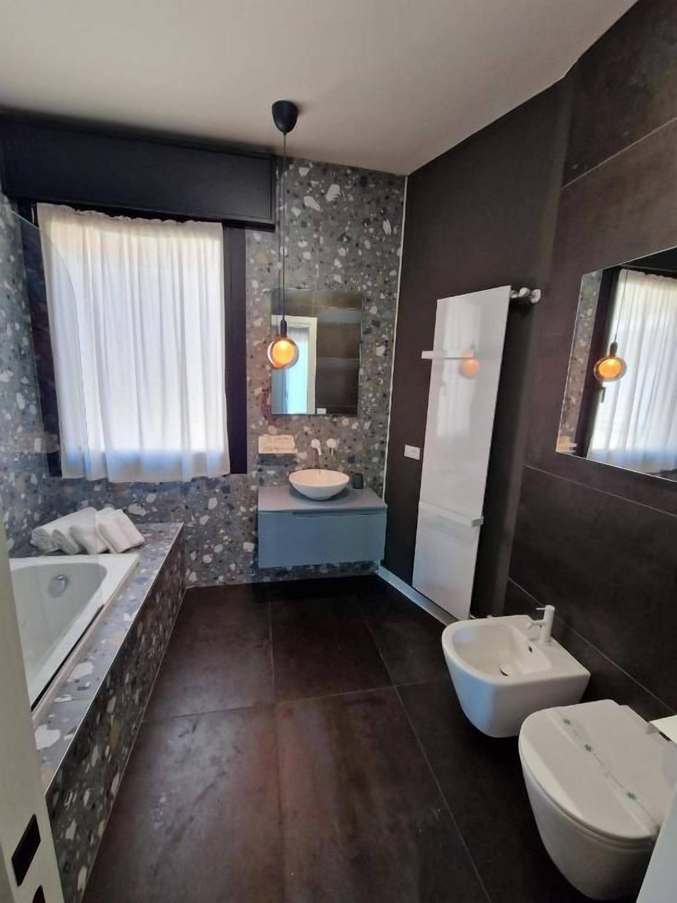 Un baño moderno con bañera, lavamanos, inodoro y bidé.