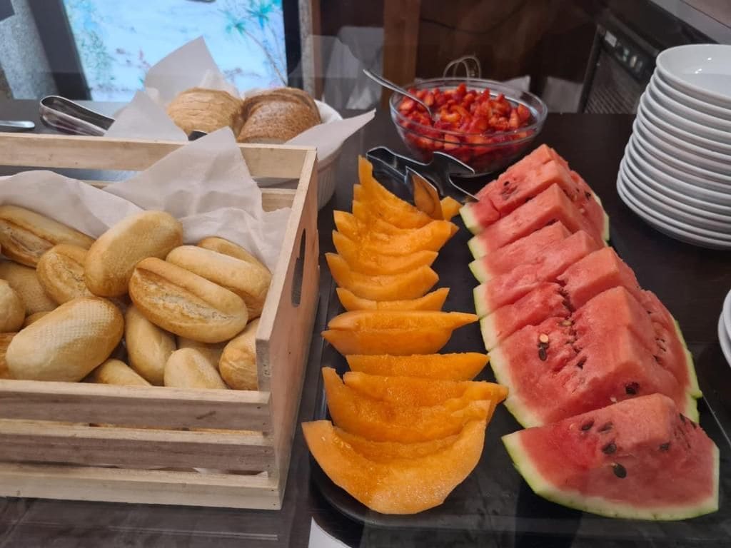 Brot, geschnittene Früchte und eine Schale Erdbeeren.