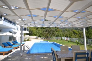 Piscine extérieure, parasols de plage, chaises longues