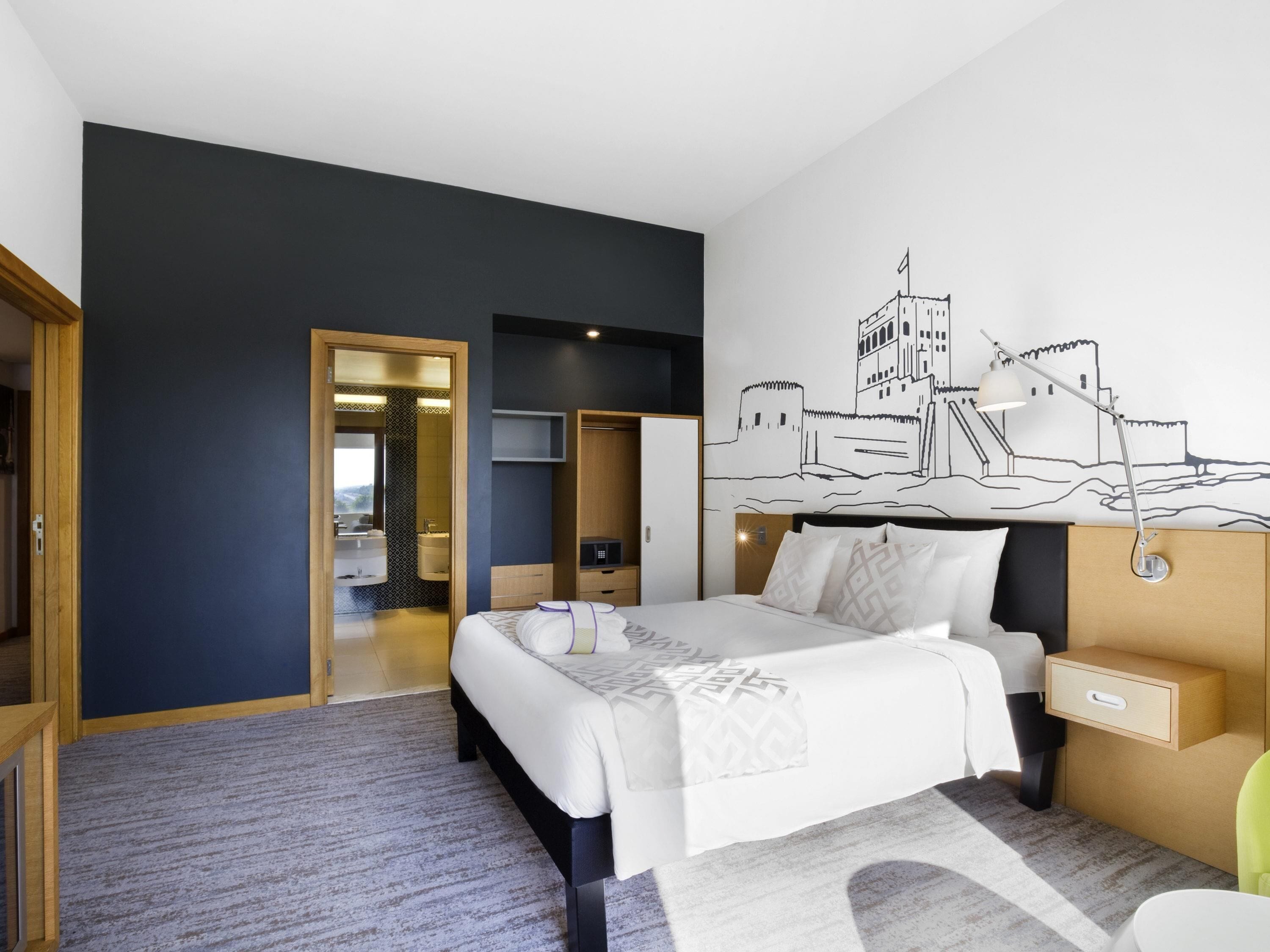 أغطية فراش متميزة وخزنة داخل الغرفة ومكتب وتجهيزات عازلة للصوت