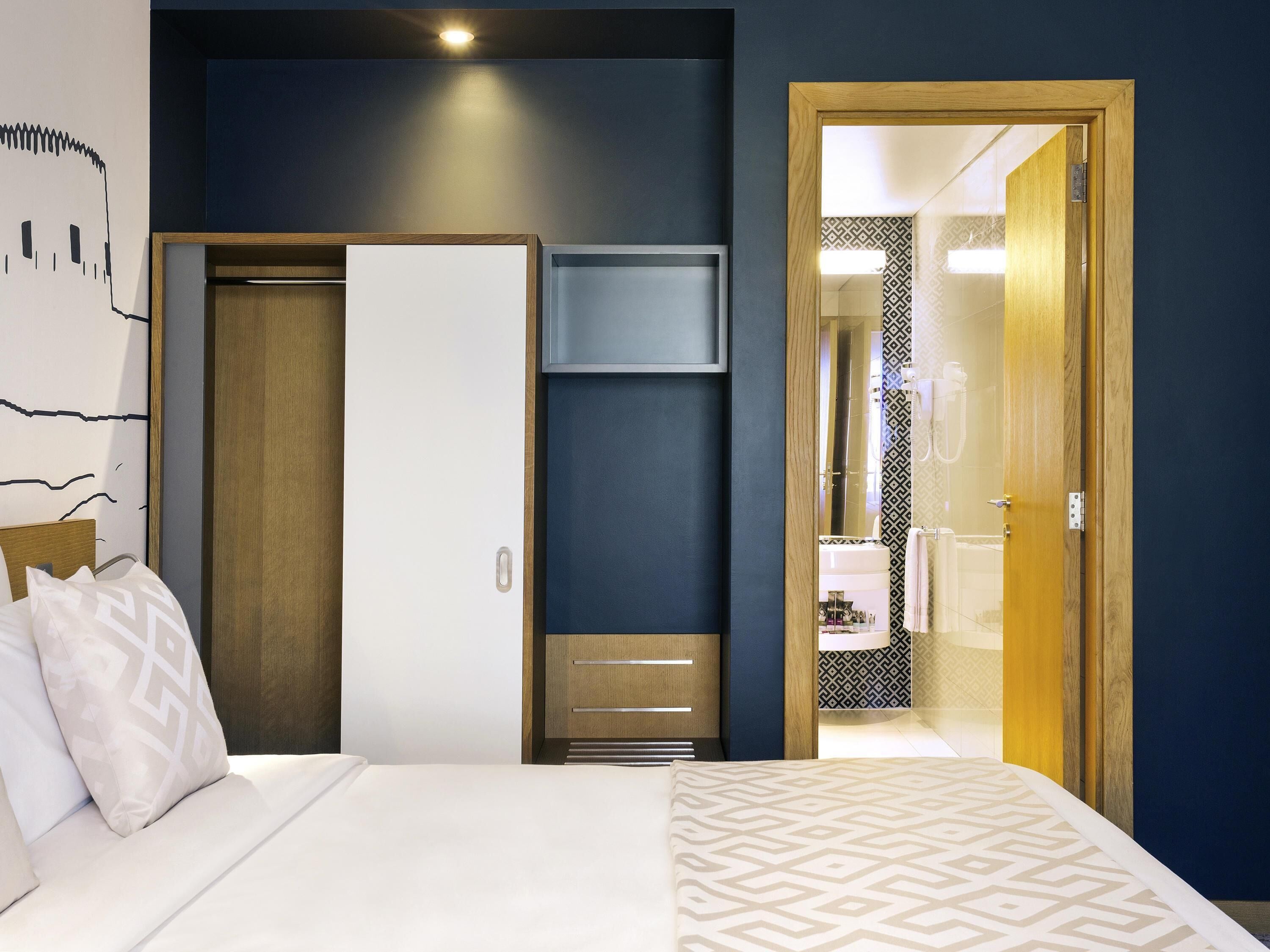 أغطية فراش متميزة وخزنة داخل الغرفة ومكتب وتجهيزات عازلة للصوت