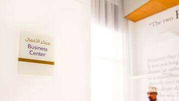 A sign with Arabic text and the English translation 'Business Center' on a wall.