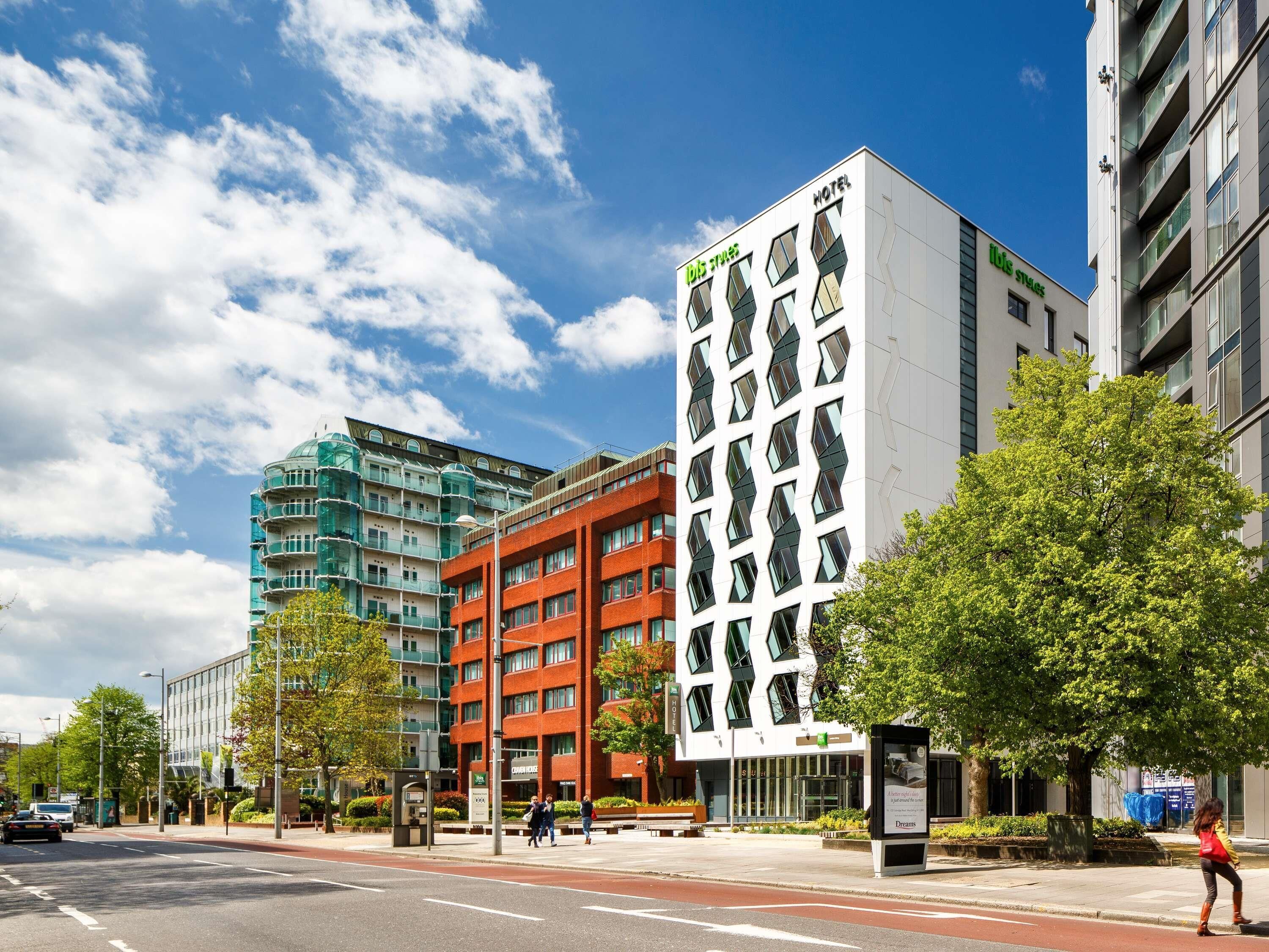 Un hôtel moderne à la façade géométrique originale, avec une enseigne « HÔTEL » bien visible et un environnement urbain soigné.