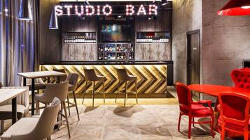 A bar area with a chevron-patterned counter and a variety of seating options including bar stools and tables.