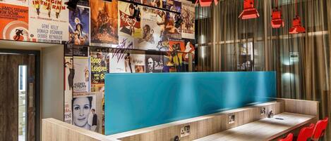 Un área de bar moderna con mostrador azul y sillas rojas.